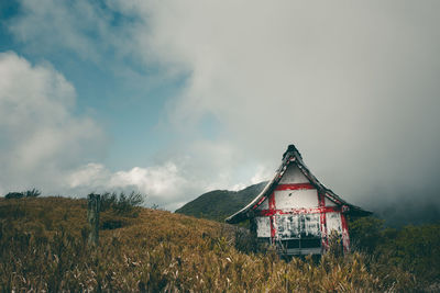 Traditional windmill on field against sky