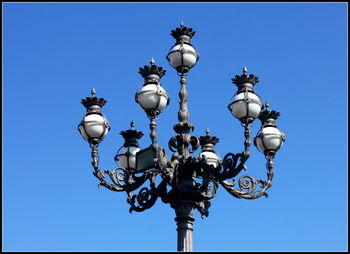 Low angle view of street light against clear blue sky