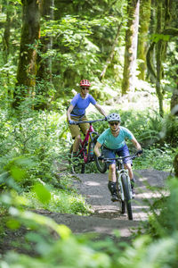 Two female bikers enjoy a trail in sandy, or near mt. hood.