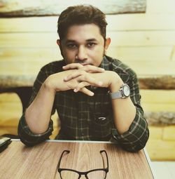 Portrait of young man sitting on table