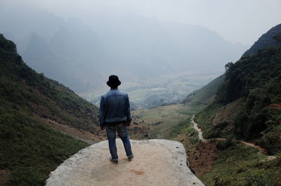 Rear view of man standing on mountain
