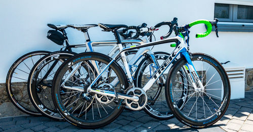 Bicycle parked on footpath against wall