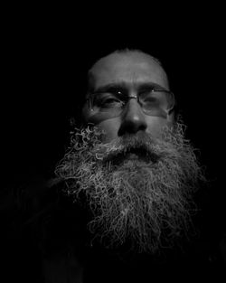 Portrait of young man against black background