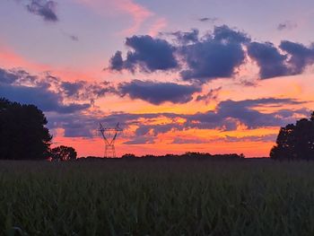 Scenic view of field against romantic sky at sunset