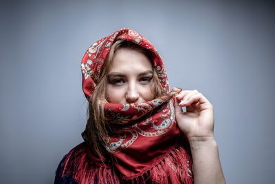 Portrait of beautiful woman against red background