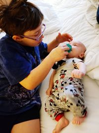 High angle view of cute baby on bed at home