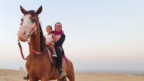 Woman and her daughter riding horse