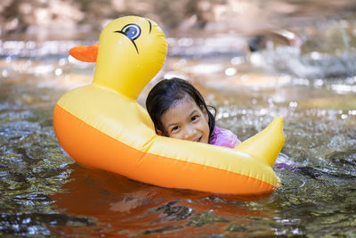 Portrait of girl with toy in swimming pool