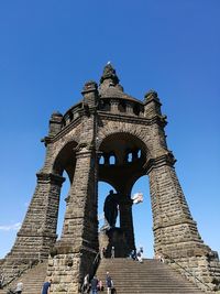 Low angle view of historical building against clear blue sky