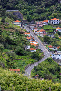 High angle view of road amidst trees and buildings in village