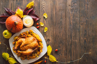 Autumn composition with leaves, ripe pumpkin and thanksgiving turkey on a dark wooden table.