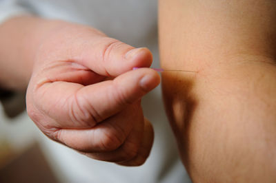 Midsection of man injecting needle on arm