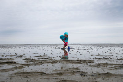 Boy on beach against sky