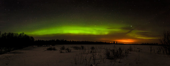 Scenic view of snow covered field against sky at night