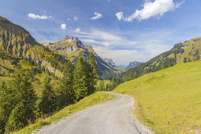 Road leading towards mountains against sky