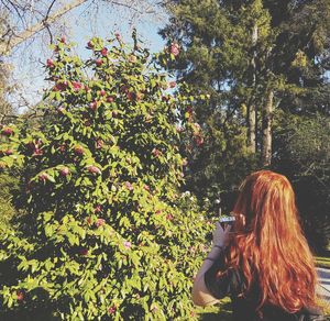 Rear view of woman standing by plants