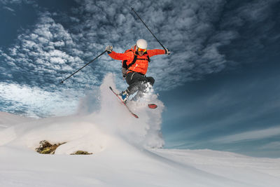 A girl makes a jump with glo skis in deep snow