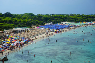 High angle view of people enjoying in sea against sky