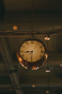 Low angle view of clock hanging on ceiling