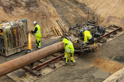 Men installing pipes on construction site