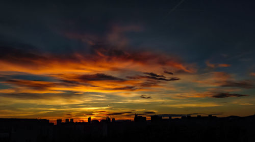 Silhouette cityscape against sky during sunset