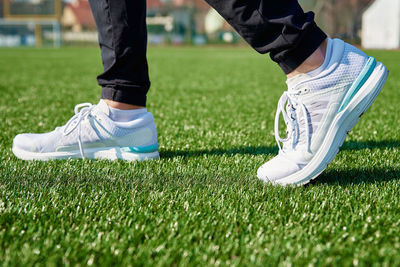 Runner feet running at stadium with green grass