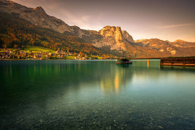 Scenic view of lake by mountains against sky