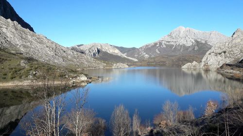 Scenic view of lake and mountains against clear blue sky