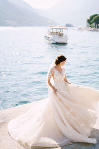 Rear view of woman sitting on boat at beach