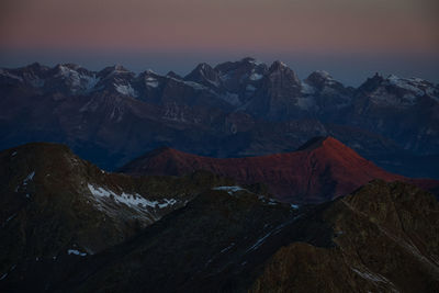 Scenic view of snowcapped mountains against sky during sunset