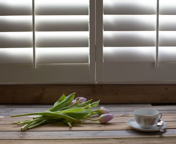 Close-up of tulips and tea cup on table