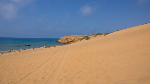 Scenic view of beach against clear blue sky