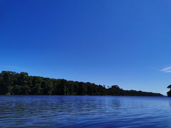 Scenic view of lake against clear blue sky