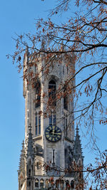 Low angle view of cross by building against clear sky