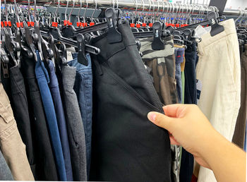 Cropped hand of woman choosing cloth in store