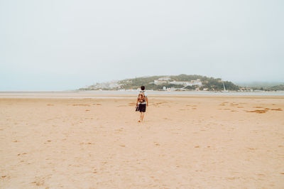Man on beach against clear sky