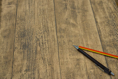 High angle view of pen and pencil on wooden table