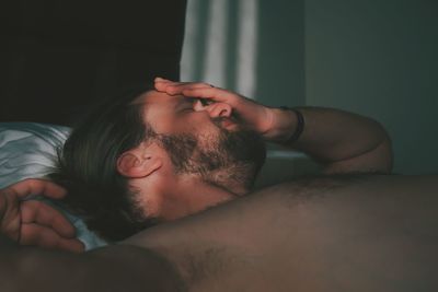 Bearded man sleeping on bed