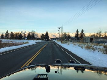 Snow covered road against sky during winter
