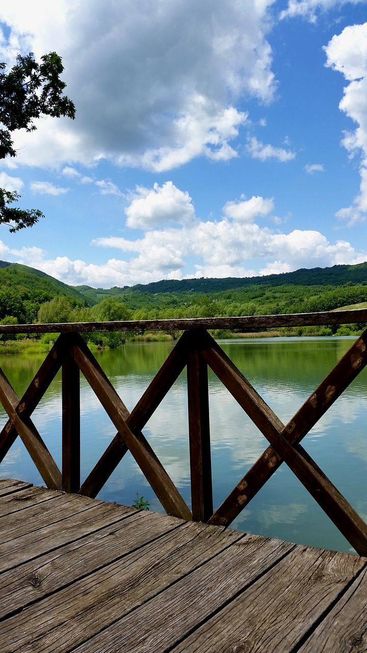 sky, water, cloud - sky, tranquility, tranquil scene, lake, cloud, fence, scenics, nature, railing, wood - material, landscape, beauty in nature, built structure, cloudy, day, river, outdoors, blue