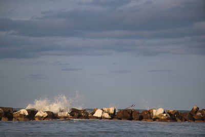 Rocks by sea against sky