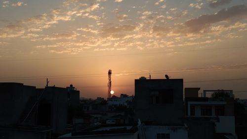 Silhouette buildings against sky during sunset