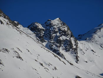 Scenic view of snowcapped mountains against clear blue sky