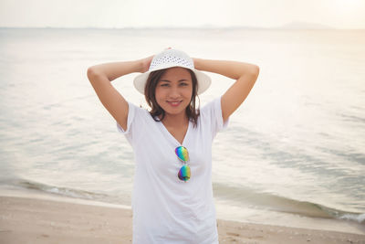 Portrait of woman at beach against sky