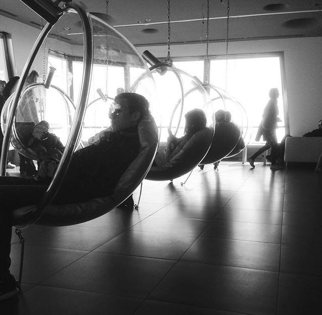 PEOPLE SITTING ON TILED FLOOR IN CORRIDOR