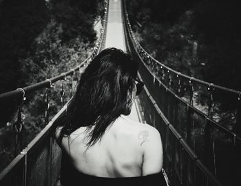 Rear view of woman standing by railing