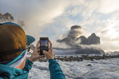 Man uses smartphone to take a photo of mount asgard.