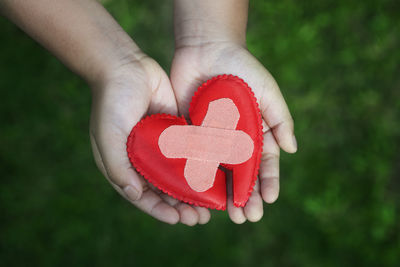 Cropped hands of person holding broken heart shape