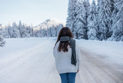 Rear view of woman walking on snow