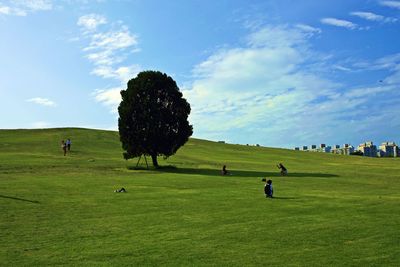 Group of people on field against sky
